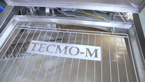 automatic mixing of milk cream inside large industrial stainless steel reservoir. large tanks for storing and fermenting dairy products. close up.