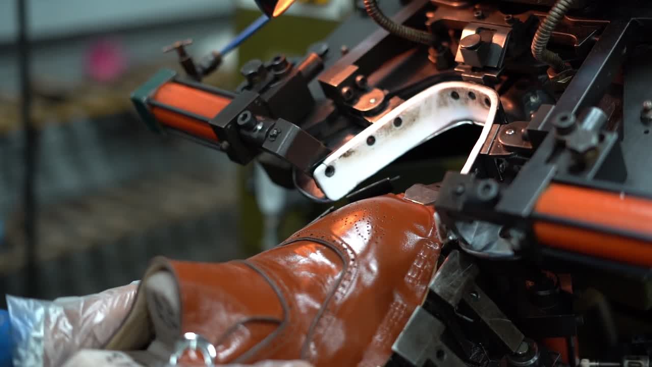 a craftsman handmade a shoe by a machine, close up shot, insert shot