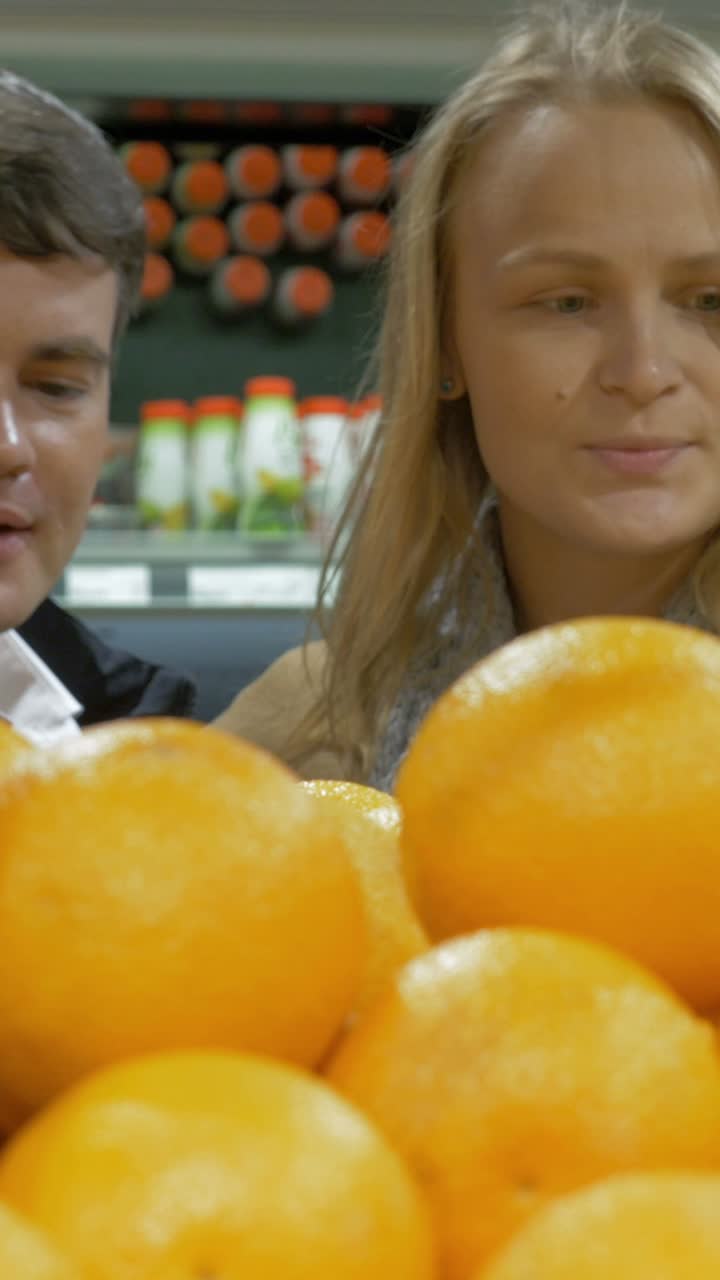 Woman buying oranges at the grocery store