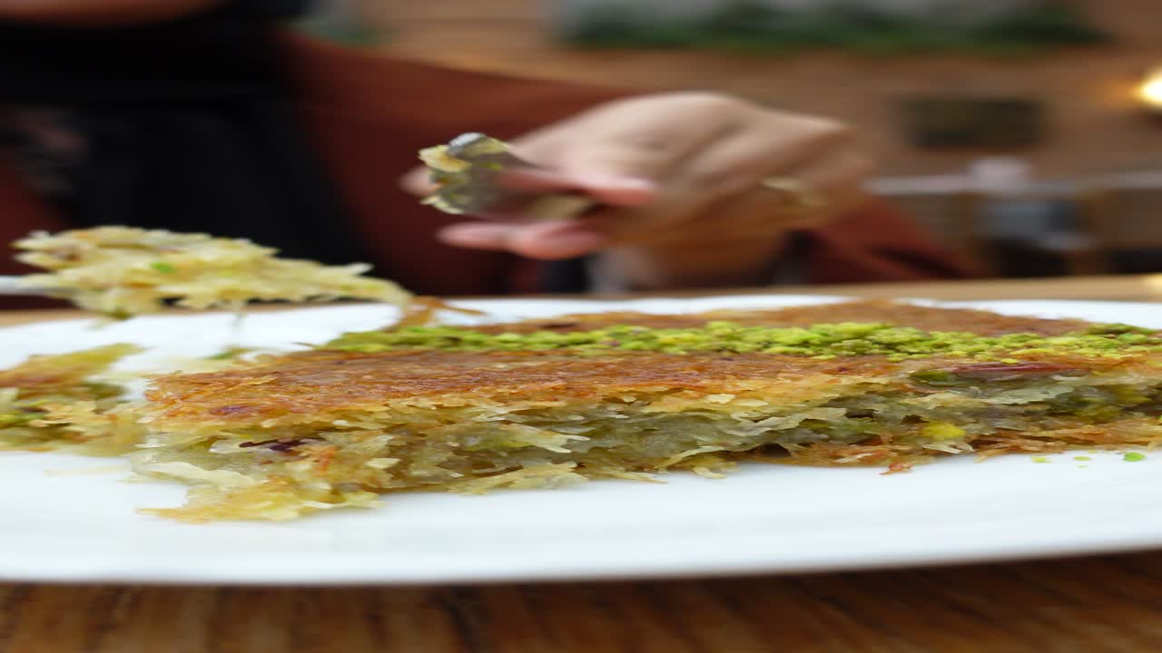 una mujer comiendo baklava.