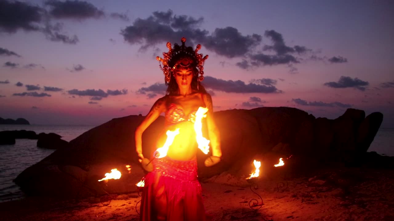 e sensuale danzatrice del ventre, che si esibisce con torce a mano infuocate, sulla spiaggia durante l'ora d'oro. Movimento lento