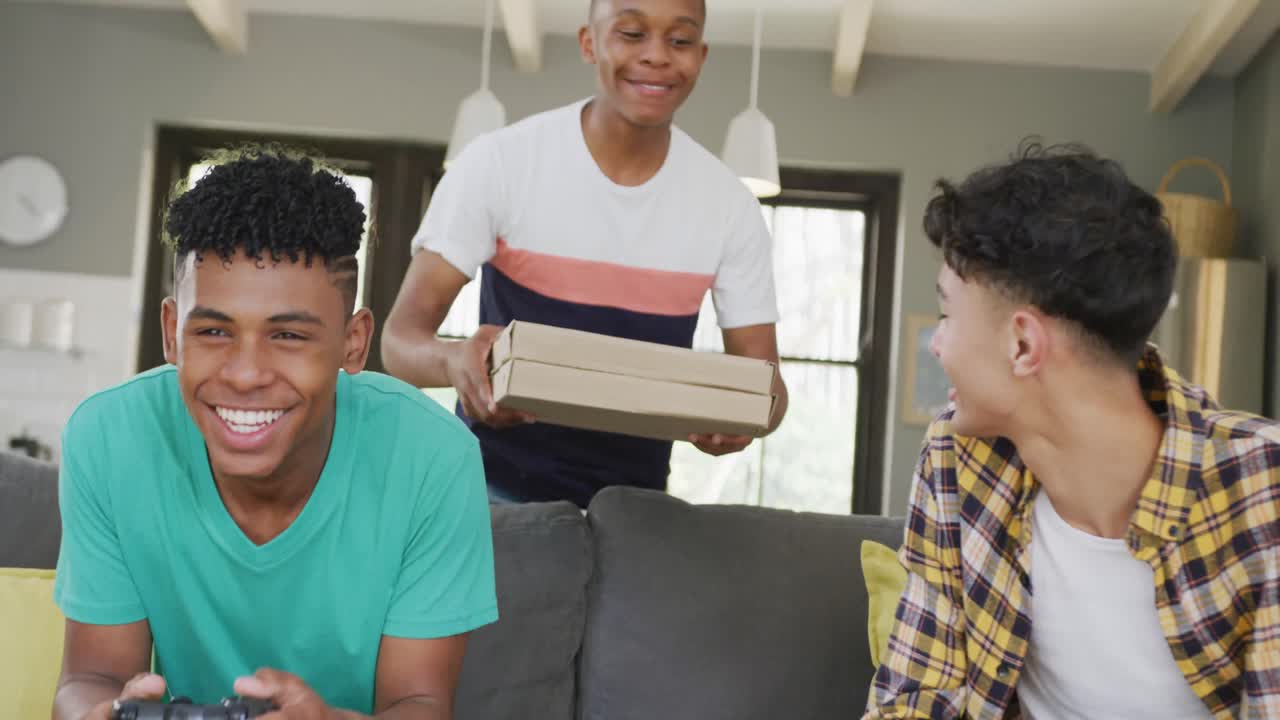 Happy diverse male teenage friends playing video games, slow motion