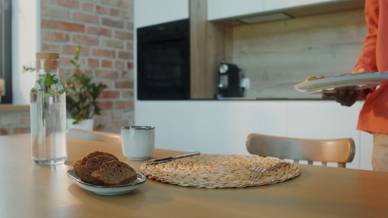 hombre usando teléfono móvil durante la comida en la cocina