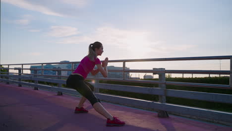 mujer estirándose en un puente al amanecer o al atardecer