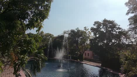 peaceful garden pond with fountains and trees on a sunny day in cuernavaca, mexico