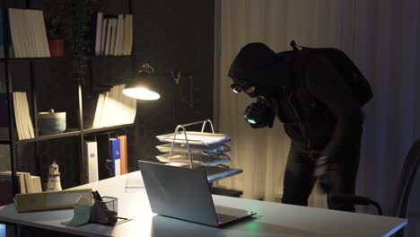 burglar man commits robbery with flashlight in office.