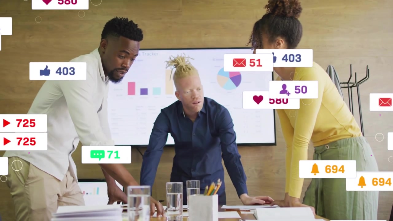 Un team si china su un tavolo, ricevendo un feed social in diretta, con icone che appaiono e analizzando i grafici della campagna.