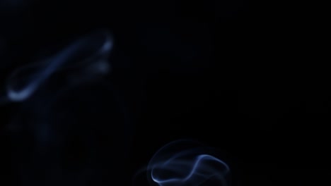 humo flotando lentamente por el espacio contra un fondo negro.