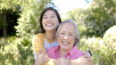 smiling women hugging each other outdoors, enjoying time together in garden