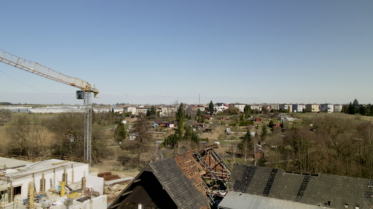 grúa en el sitio de construcción junto a las ruinas de una casa abandonada en lubawa, polonia