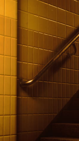 yellow tiled wall with handrail on a staircase