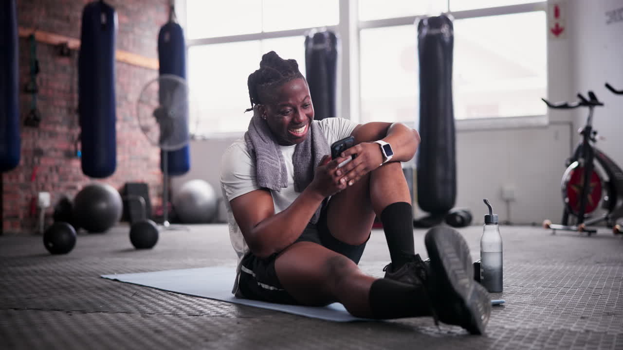 Pria bersantai di gym dengan ponsel