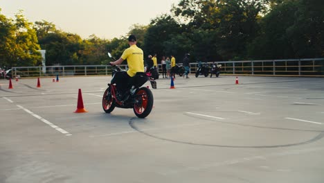 a man in a yellow t-shirt driving instructor rides and overtakes obstacles on a bike. riding training in a motorcycle school