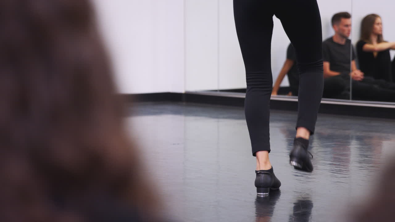 Primo piano di una studentessa di tip tap che si esibisce per la lezione in studio in una scuola di arti performative.