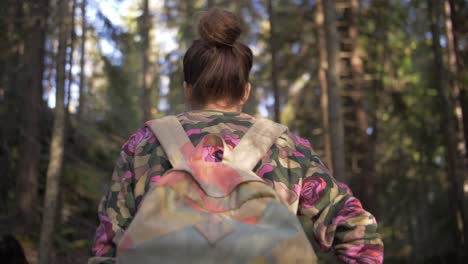 Junge-Frau-Mit-Einer-Tasche-Geht-In-Zeitlupe-In-Einem-Wald-Mit-Braunen-Haaren-Und-Verschwommenem-Hintergrund-Spazieren