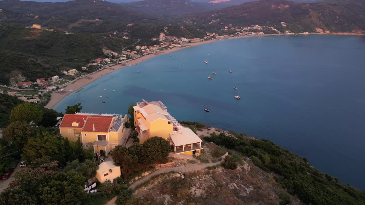 A drone captures a breathtaking scene of a hillside home, nestled near the beach, with sweeping views of the shoreline and serene surroundings.