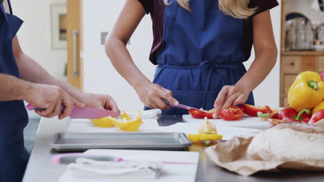 Estudiantes-Adultos-Masculinos-Y-Femeninos-Cortando-Pimientos-Para-Un-Plato-En-La-Clase-De-Cocina