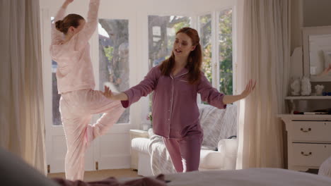 happy teenage girls practicing ballet dance moves in bedroom best friends having fun rehearsal on weekend morning wearing pajamas