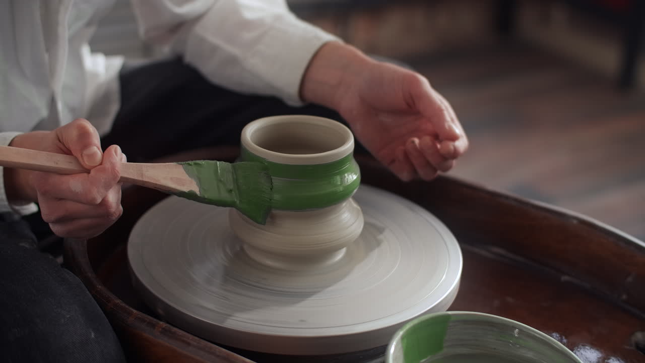 Pottery Artist Painting a Ceramic Piece on a Pottery Wheel