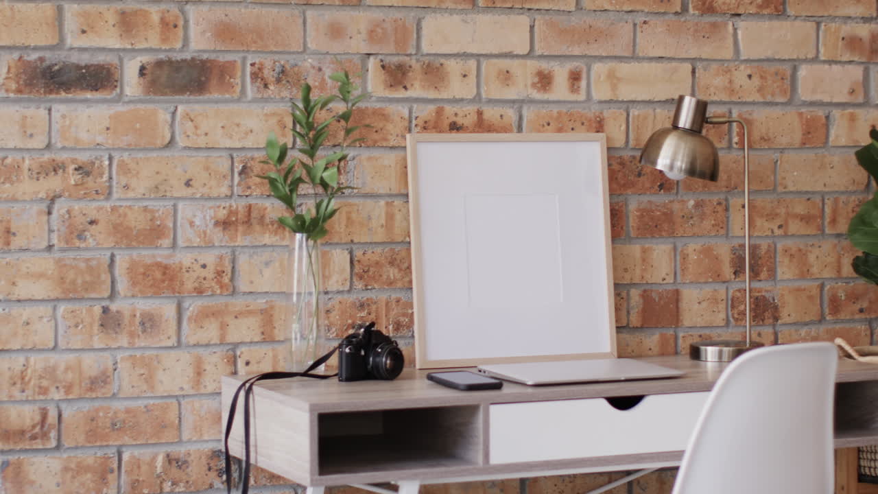 marco de madera con espacio de copia en fondo blanco con planta en el escritorio contra la pared de ladrillo