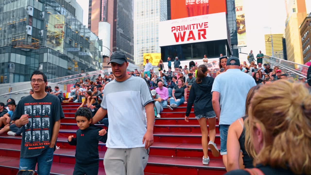 New York, USA, 8 October 2025: Crowded Times Square at daytime. Lots of people having rest on the stairs of the famous landmark. New York, USA