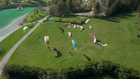 kitesurfers on meadow along shores of molveno lake, trentino in italy