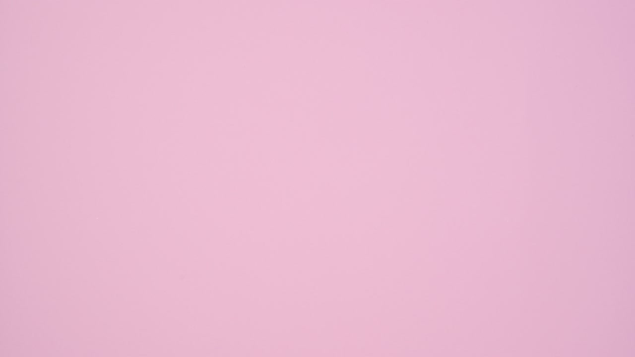 Silver gift with dark blue ribbon passing on right side of pastel pink theme. Stop motion