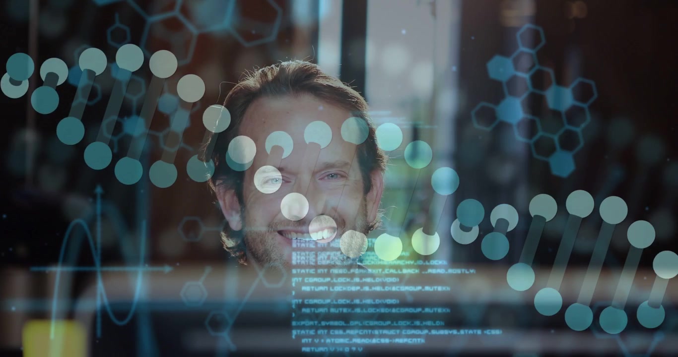 Man sitting behind monitor, overlays appearing, adjusting glasses, analyzing tech code, smiling