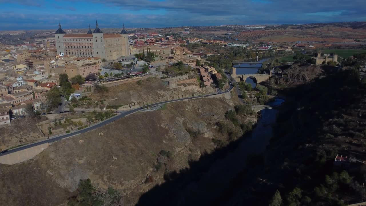 Aerial view overlooking Alcázar of Toledo and dramatic canyon with Puente de Alcántara - Toledo, Spain