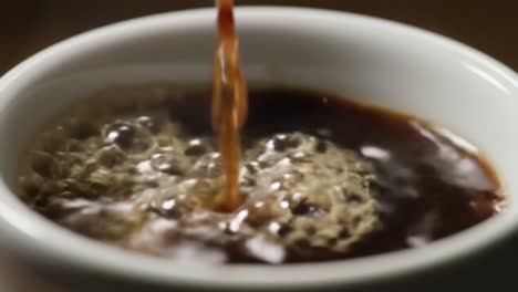a close-up journey into the art of coffee brewing: witnessing the transformation as rich brown liquid flows into a white cup, capturing the essence of flavor and aroma