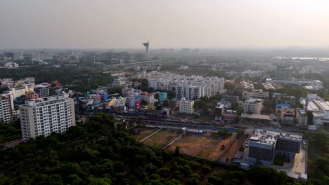 high-angle aerial view of a sprawling urban landscape in coimbatore, india, a mix of residential and commercial structures. in the foreground and mid-ground, there's a blend of established low-rise