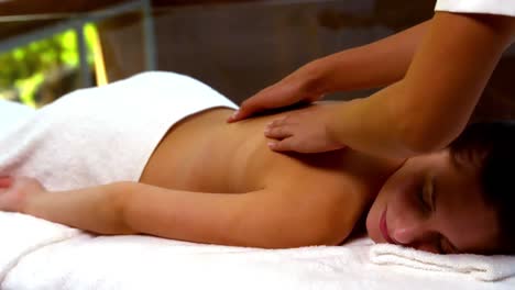 Peaceful-woman-enjoying-a-back-massage-at-the-spa