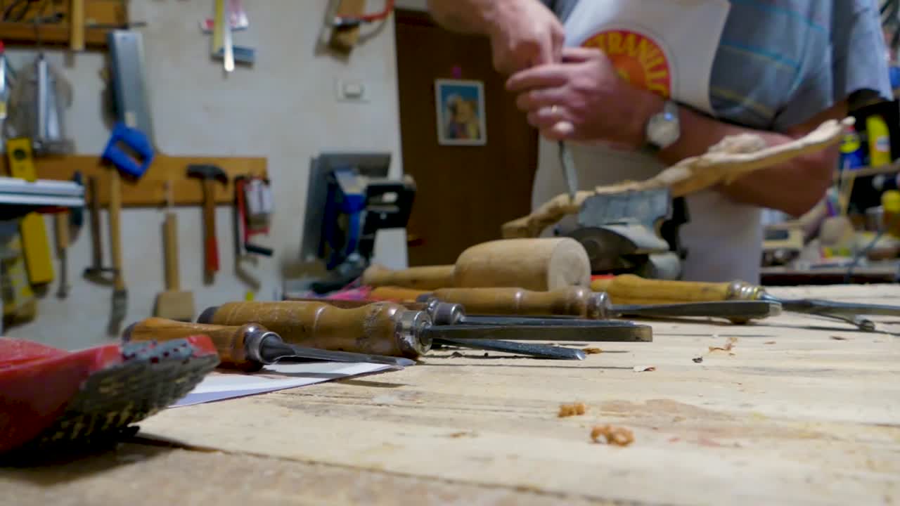 Italian Sculptor in his workshop working on a olive wood statue