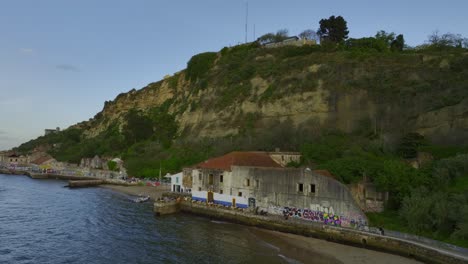 drone shot of some abandon building along the river side in almada, portugal