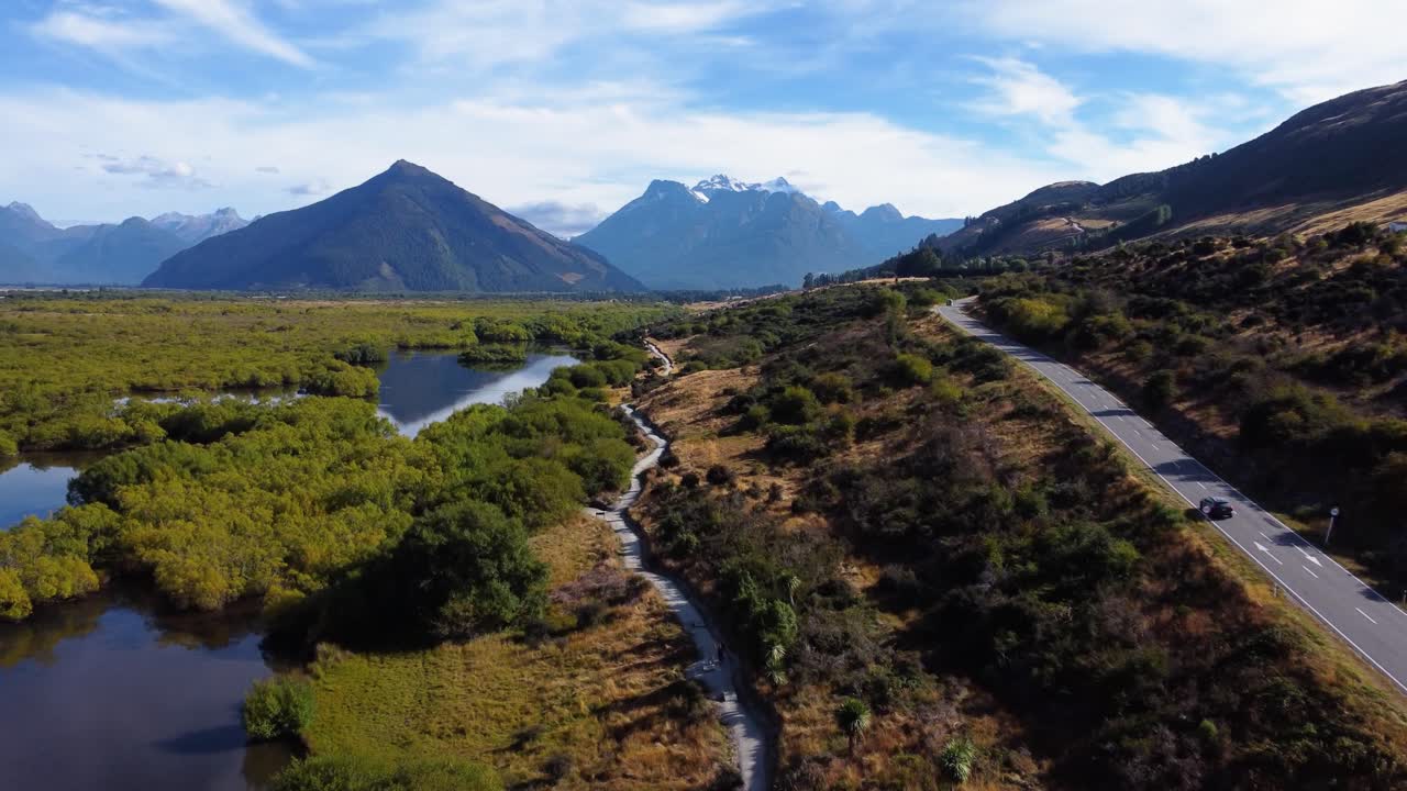 Sorvolo aereo su uno splendido paesaggio montano attraversato da una strada a Glenorchy, Nuova Zelanda.