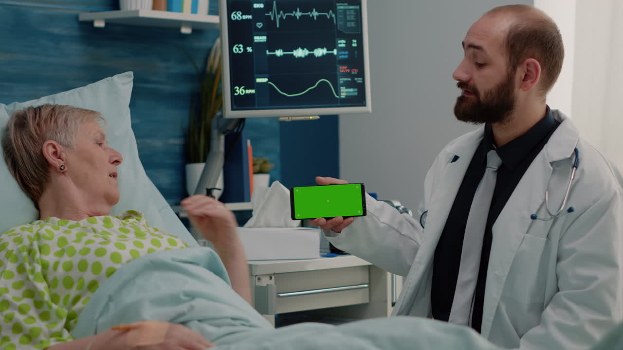 Retired patient looking at horizontal green screen on phone