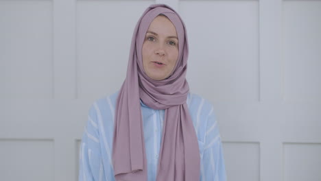 selbstbewusste junge indische muslimische geschäftsfrau trägt hijab, spricht, schaut auf die kamera, islamische arabische dame spricht mit der webcam, macht videokonferenzgespräche, nimmt vorstellungsgespräche auf, nimmt webinar auf, präsentiert sich online im büro