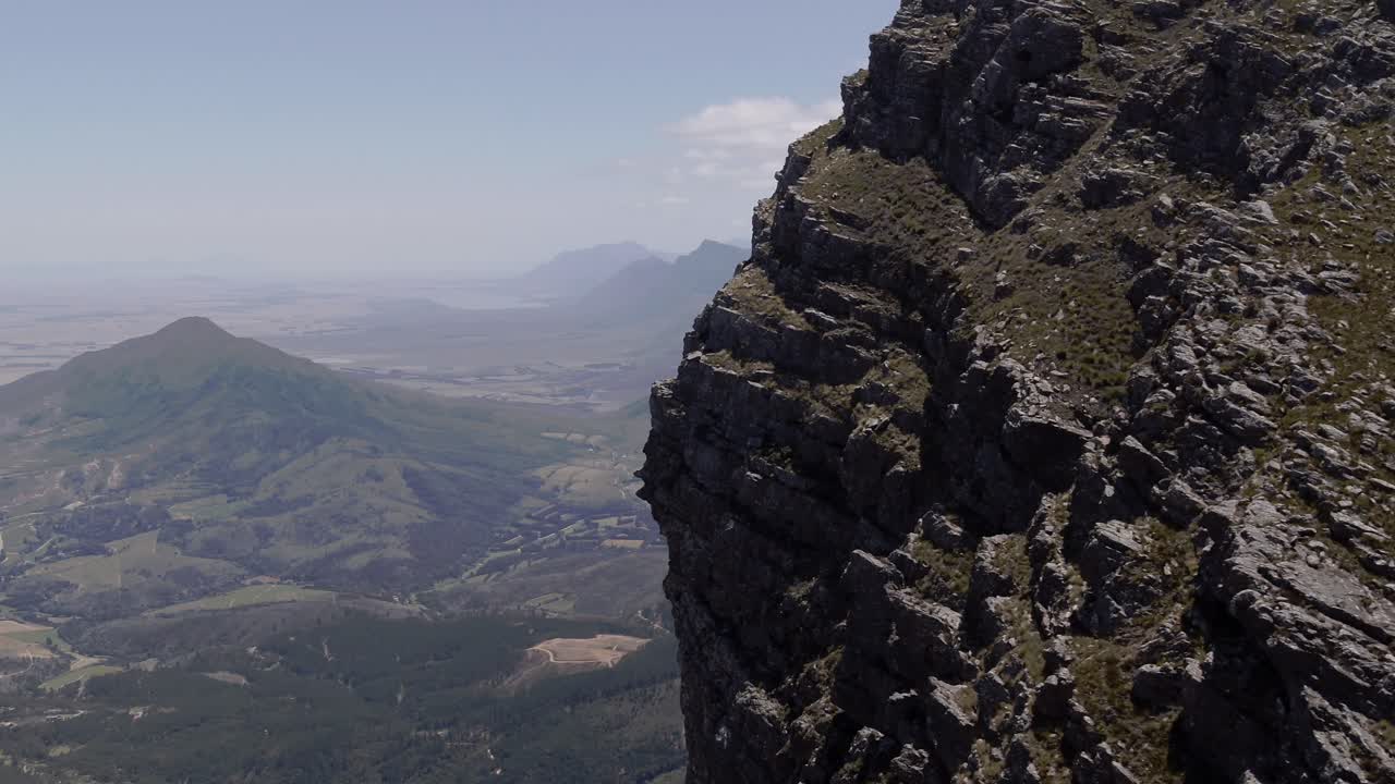 tomada aérea de un dron de 4k en órbita en la cara de la montaña rocosa cerca de la cordillera de paarl du toitskloof, cabo occidental, sudáfrica