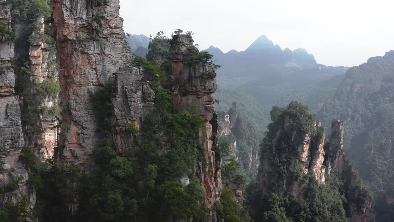 empuje aéreo inclinado hacia arriba a través de zhangjiajie, wulingyuan hunan china vista panorámica de un paisaje nublado y brumoso avatar