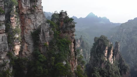 aerial push in tilt up across zhangjiajie, wulingyuan hunan china panoramic view of cloudy hazey avatar like landscape