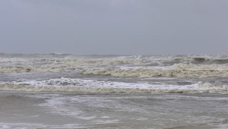 strong waves strike a beach during a tropical storm