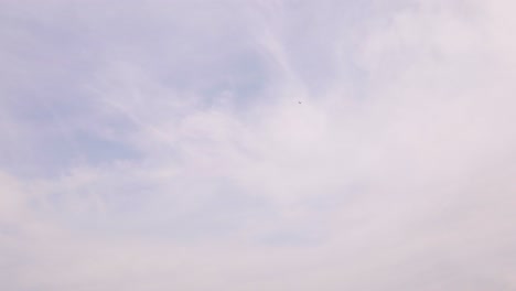 low flying passenger plane crossing a beautiful blue sky with veil clouds