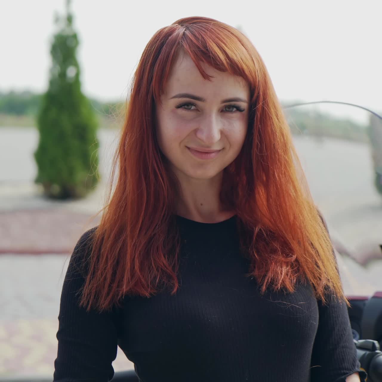 . Girl posing against motorcycle. Woman rider with his motorbike