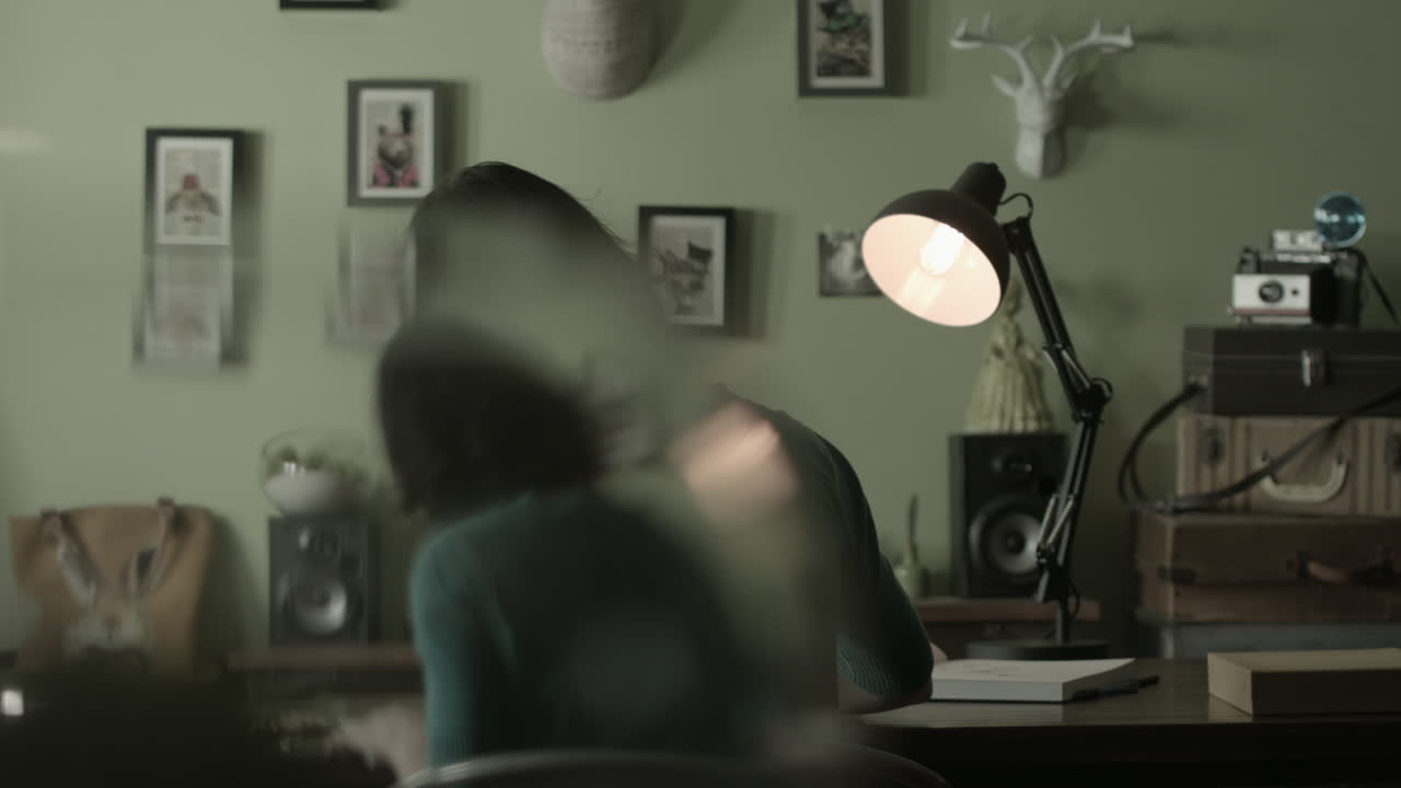 한 여자 가 책상 램프  에서 집 에서 일 하고 있다