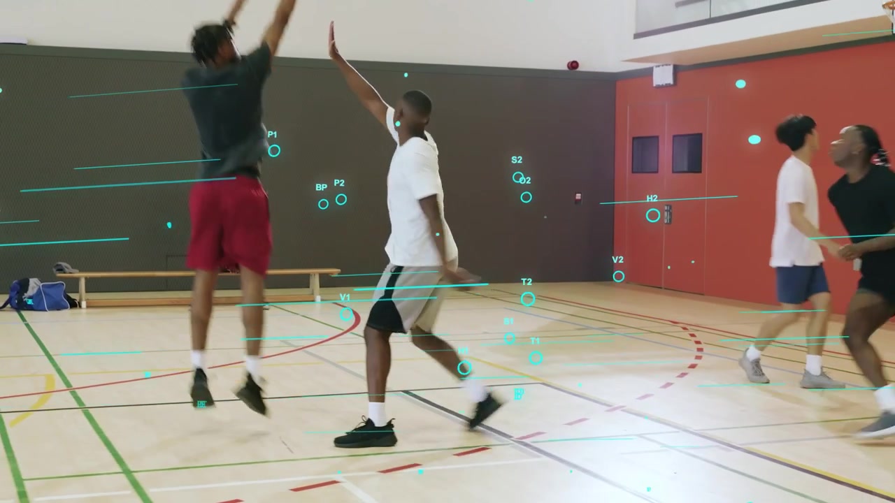 Cinq hommes s'entraînent sur un terrain de basket-ball en salle, un joueur dribble, des passes créent des ouvertures, en pleine pratique.
