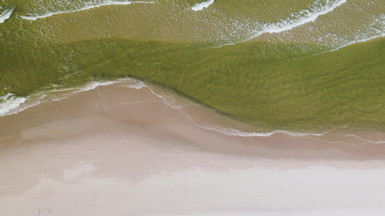 하얀 모래 해변, 폴란드의 해안에 구르는 잔잔한 파도의 하향식