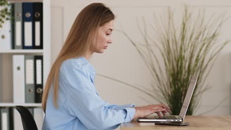 mujer trabajando en una computadora portátil en la oficina