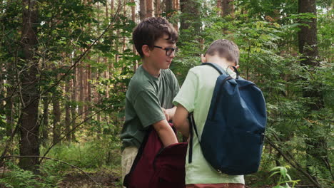 two kids with backpacks in the forest