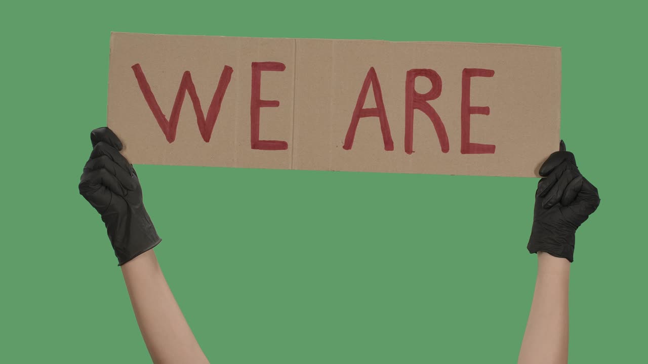 우리는 카드보드에 항의 문자 메시지, 인종차별을 멈춰라, 경찰 폭력, 배너 디자인 개념, 포스터를 들고 있는 검은 장갑을 입은 손, 녹색 화면, 크로마 키, 클로즈업, 느린 동작.