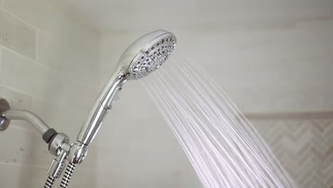 Chrome-shower-head-is-turned-on-where-hot-water-comes-out-and-then-turned-off-again